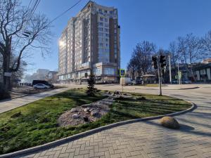 a large building on a city street with a park at Dendrarium Park Apartment Deluxe in Chişinău