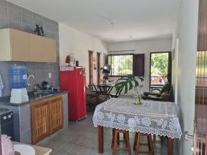 a kitchen with a table and a red refrigerator at Residencial Coroa Vermelha in Santa Cruz Cabrália