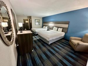a hotel room with two beds and a couch at Baymont by Wyndham Kansas City KU Medical Center in Kansas City
