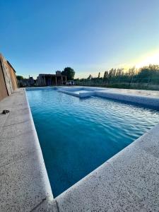 a large swimming pool with blue water at Complejo ROSA OLIVA in Albardón