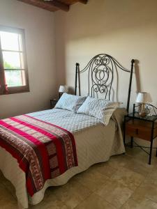 a bedroom with a bed with a wrought iron headboard at Complejo ROSA OLIVA in Albardón