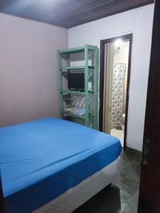 Mangue House lll في ريو دي جانيرو: غرفة نوم بسرير ازرق ورف اخضر