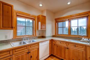 cocina con armarios de madera, fregadero y 2 ventanas en Expedition Station Condominiums by Keystone Resort en Keystone