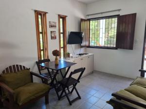 a living room with a table and chairs and a tv at Residencial Coroa Vermelha in Santa Cruz Cabrália