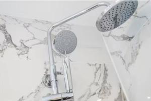 a shower with a shower head on a marble wall at Great Location Service and Stay Double Ensuite Room - 5mins Walk From Tufnell Park in London