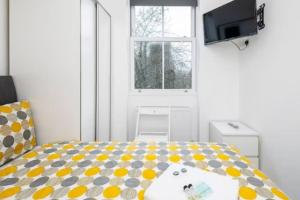a small room with a bed and a television at Great Location Service and Stay Double Ensuite Room - 5mins Walk From Tufnell Park in London