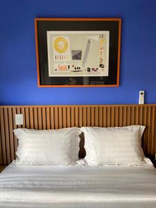 Un dormitorio con una pared azul y una cama con almohadas blancas. en 22 Cozy New Studio near Paulista Fast WI-FI, en São Paulo