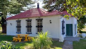 ein kleines weißes Haus mit einem Picknicktisch davor in der Unterkunft Casa de Campo Finca La Superiora in La Consulta