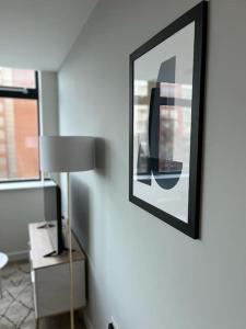 a room with a lamp and a picture on the wall at Fantastic one bedroom apartment near Old Trafford Stadium in Manchester +9 photos