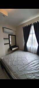 a bedroom with a large bed with a window at Apartment pancoran in Jakarta