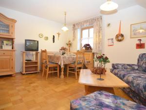 uma sala de estar com uma mesa e um sofá em Cozy group house with its own garden and wellness area em Schönsee
