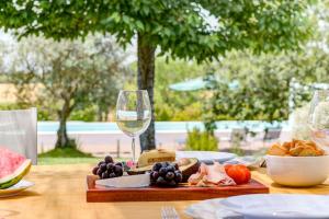 una mesa con un plato de comida y una copa de vino en Casa Koya- Luxury house in the countryside 