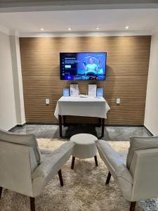 ein Zimmer mit einem Tisch und zwei Stühlen und einem Fernseher in der Unterkunft Chale Ouro Verde - Serra de Guaramiranga in Baturité