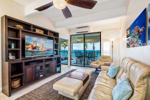 a living room with a couch and a tv at Oceanfront Luxury Condo in Kailua-Kona