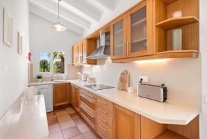 a kitchen with wooden cabinets and white counter tops at Diane in Binibeca