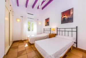 ビニベカにあるDianeの白い壁と紫色の天井が特徴の客室で、ベッド2台が備わります。
