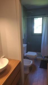 baño con 2 aseos, lavamanos y ventana en Paihuen: casa moderna con vista en San Carlos de Bariloche