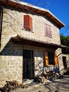 a stone house with two windows and a door at La Salira 