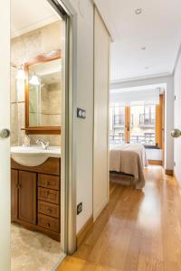 La salle de bains est pourvue d'un lavabo, d'un miroir et d'un lit. dans l'établissement Luxury Old TownGeneral Jauregi, à Saint-Sébastien