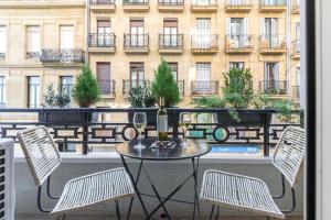 a table and chairs on a balcony with a building at Luxury Old TownGeneral Jauregi in San Sebastián