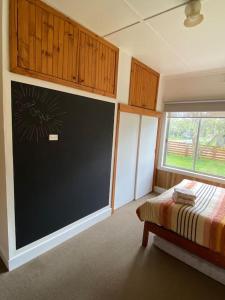 a classroom with a chalkboard and a bed and a window at Family cottage with Spa in Cowes