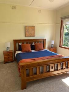a bedroom with a wooden bed and a window at Family cottage with Spa in Cowes