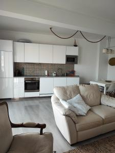 a living room with a couch and a kitchen at Milu house in Faro