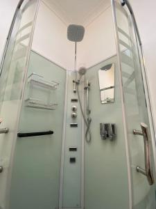 a bathroom with a shower with a glass door at Family cottage with Spa in Cowes