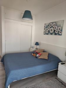 1 dormitorio con 1 cama con edredón azul en Milu house, en Faro