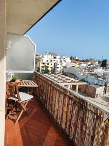 a balcony with a table and a view of a city at Milu house in Faro