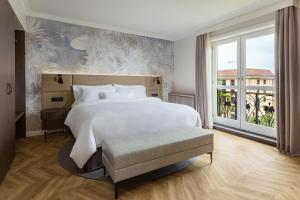 a bedroom with a large white bed and a window at The Westin Grand Berlin in Berlin