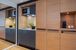 a kitchen with wooden cabinets and a sink at The Westin Grand Berlin in Berlin