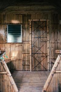 une porte ouverte dans une grange en bois avec une fenêtre dans l'établissement Loko Amigos Bohol Panglao, à Mormol