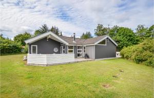 a small house with a dog sitting in a yard at Lovely Home In Ebeltoft With Swimming Pool in Ebeltoft