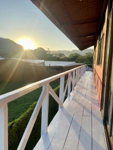 ハコにあるHotel Adventure Lodgeの夕日を背景に望む家のバルコニー