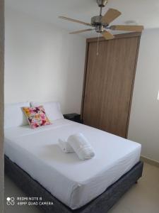 - une chambre avec un lit et un ventilateur de plafond dans l'établissement Condominio, Bello Horizonte Plaza, Santa Marta., à Santa Marta