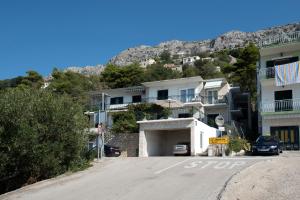 un aparcamiento frente a un edificio con una montaña en Apartment Brela 16603b en Brela