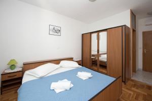 a bedroom with a blue bed with white pillows at Apartment Brela 16603b in Brela