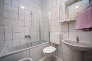 a white bathroom with a toilet and a sink at Apartment Brela 16603b in Brela +26 photos