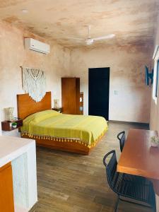 - une chambre avec un lit, une table et des chaises dans l'établissement Hotelito YUM KAAX, à Mérida