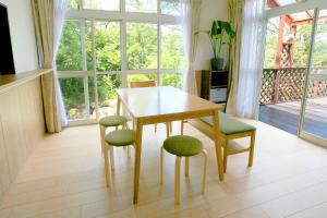 uma sala de jantar com uma mesa e cadeiras e uma janela em Y's あたみんち em Atami