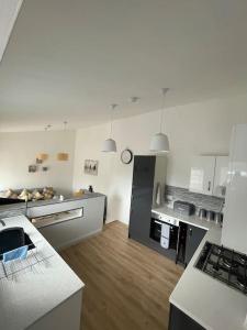 a large kitchen with white appliances and wooden floors at Fife coastal corner in Buckhaven