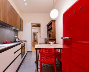 a red kitchen with a table and red chairs at Cuore della città by Home a porter in Turin