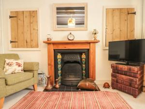 a living room with a fireplace and a flat screen tv at 12 Castlegate in Pickering