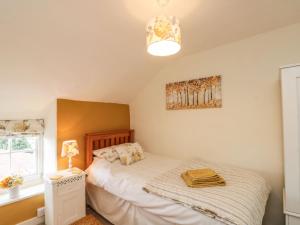 ピカリングにある12 Castlegateのベッドルーム1室(ベッド1台、ランプ、窓付)