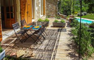 eine Terrasse mit einem Tisch, Stühlen und einem Pool in der Unterkunft Nice Home In Dieulefit With Outdoor Swimming Pool in Dieulefit