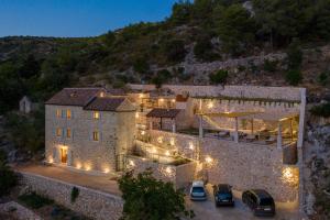 ein Grundstück mit Autos, die vor einem Gebäude mit Lichtern geparkt sind in der Unterkunft Luxury villa with a swimming pool Malo Grablje, Hvar - 20606 in Hvar