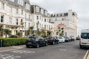 a line of cars parked in front of a building at Spacious 2 bedroom flat near beach and town centre in Bournemouth