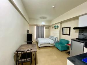 a small room with a bed and a table and chairs at Simple Studio Unit N Centrio Tower in Cagayan de Oro