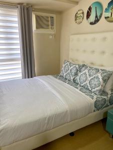 a bedroom with a bed and a window at Simple Studio Unit N Centrio Tower in Cagayan de Oro